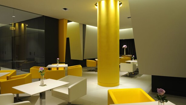 A modern interior with yellow and white furniture, a large central column, and glass partitions. - Jinjiang Inn Shanghai Huaihai Road East (Shanghai)