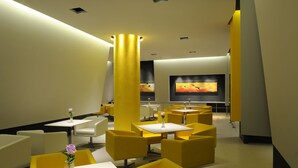 A modern lounge area with yellow and white furniture, a large screen, and a minimalist design. - Jinjiang Inn Shanghai Huaihai Road East (Shanghai)