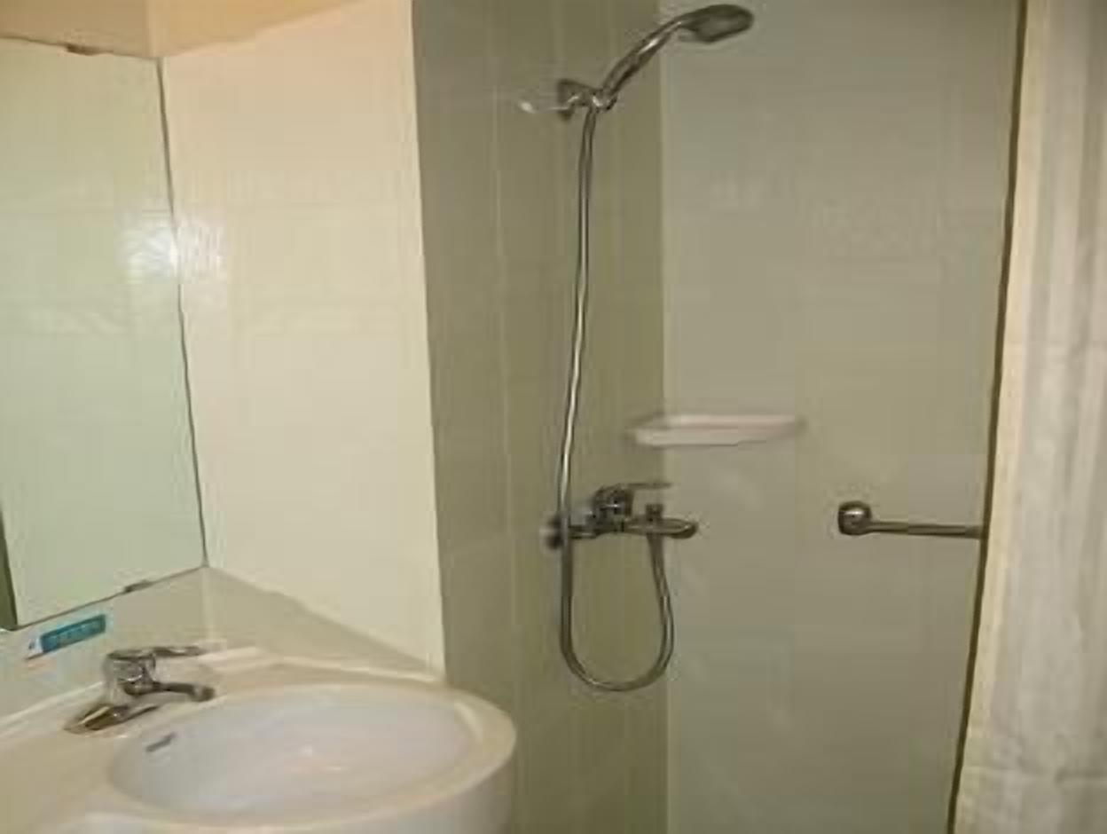 A bathroom with a shower, a sink, and a mirror.