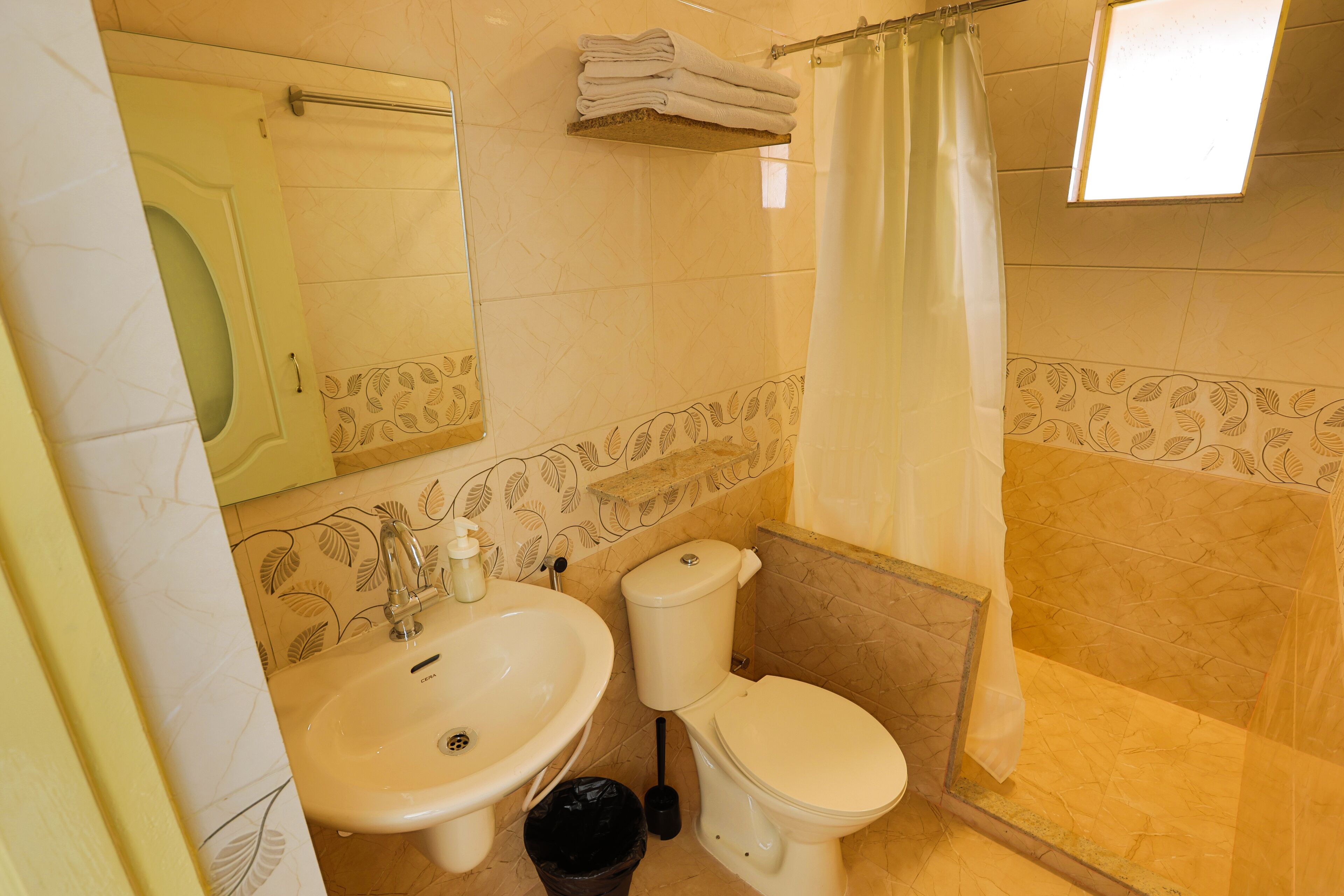 Une salle de bain avec un lavabo, des toilettes et un rideau de douche.