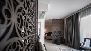 A modern living room with a patterned partition, a sofa, and a chair. - Luxor e Cairo The Beach Resort (Jesolo)