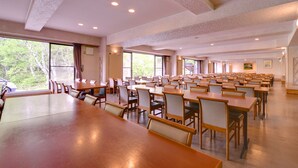 A large conference room with multiple tables and chairs, large windows, and a high ceiling with recessed lighting. - Shiga Lake Hotel (Yamanouchi)
