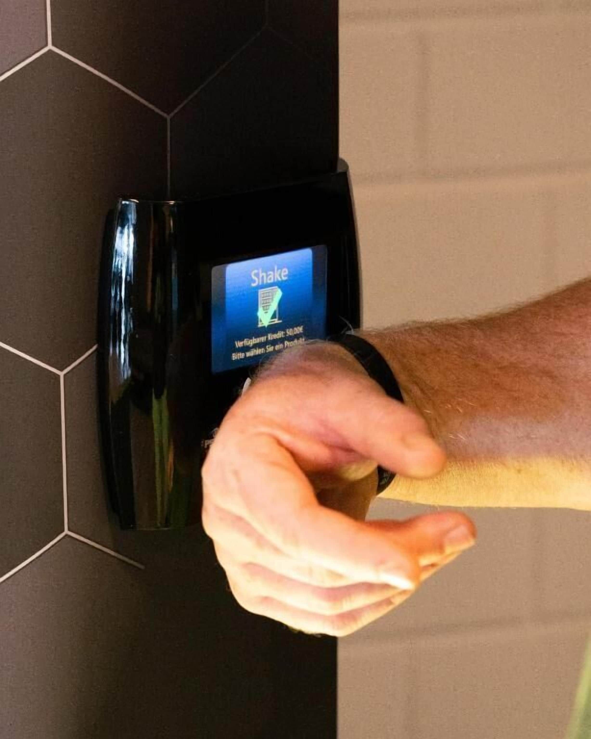 Una mano interactuando con una interfaz digital en un dispositivo montado en la pared.