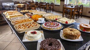 A buffet table with various baked goods and desserts. - Hotel Leão da Montanha (Campos do Jordão)
