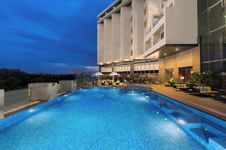 Una piscina al aire libre, sillones reclinables de piscina