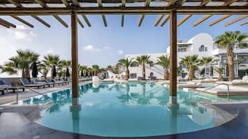 Una piscina al aire libre, sillones reclinables de piscina
