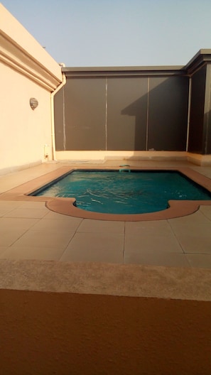 Una piscina rectangular con un borde empedrado alrededor.