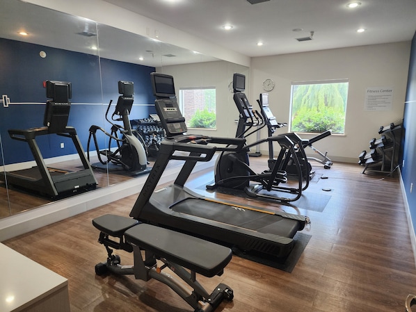 A fitness center with treadmills, elliptical machines, and weight machines.