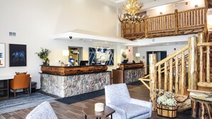A lobby with a stone reception desk, wooden staircase, and seating area. - Holiday Inn Express Hotel & Suites Donegal by IHG (Stahlstown)