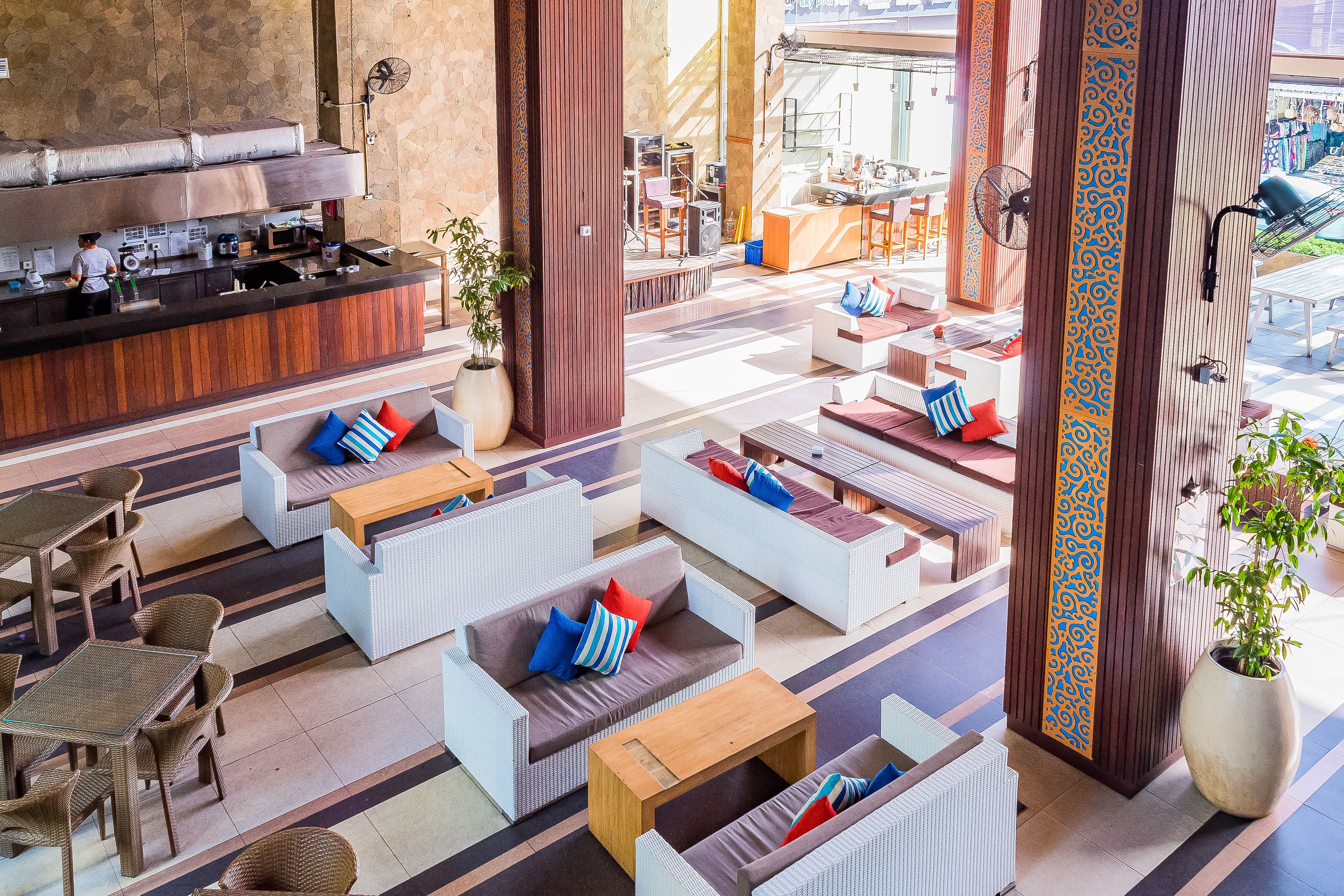 A modern lounge area with seating arrangements, a bar, and a view of the outdoor space.