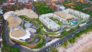 Vista aérea de un complejo turístico con varias construcciones, una piscina y una zona de playa.