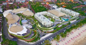 An aerial view of a resort with multiple buildings, a swimming pool, and a beach area.
