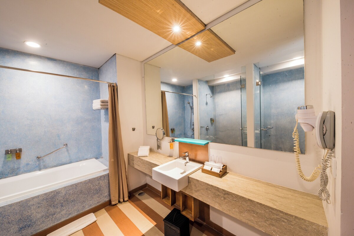 A modern bathroom with a bathtub, a sink, and a mirror.