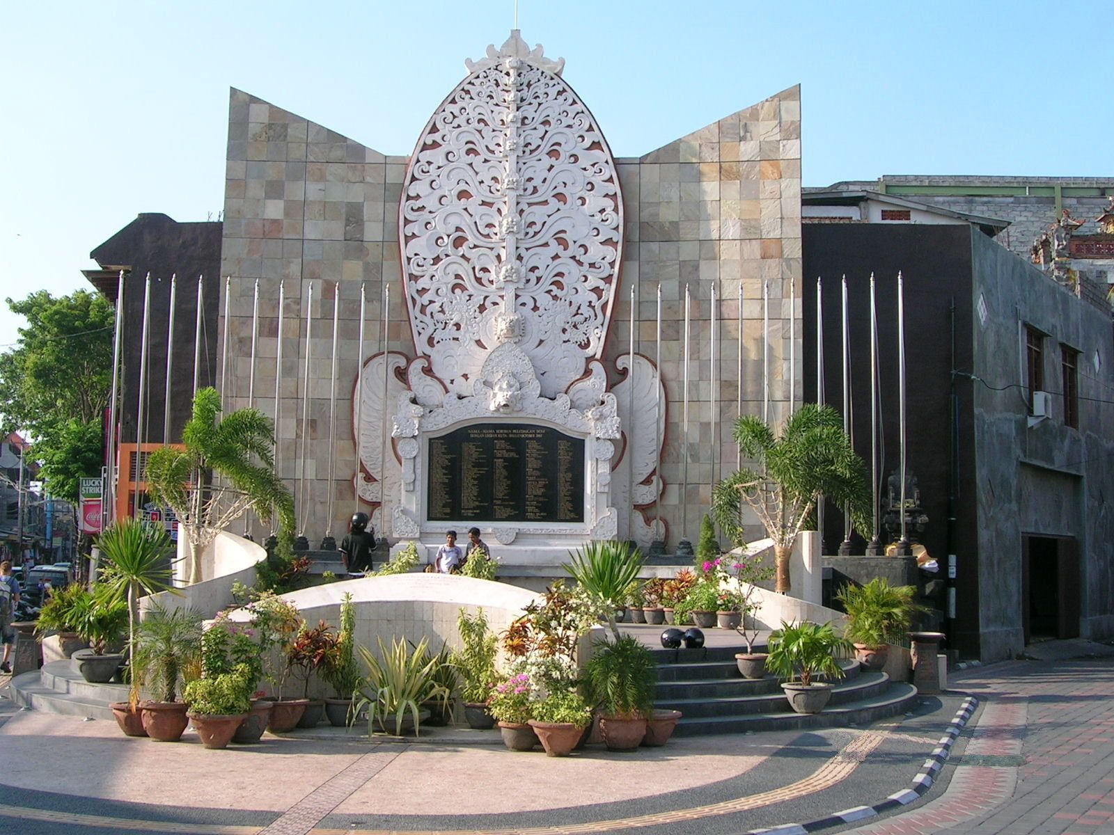 A building with a large, ornate entrance featuring a central decorative panel and a staircase leading up to it.