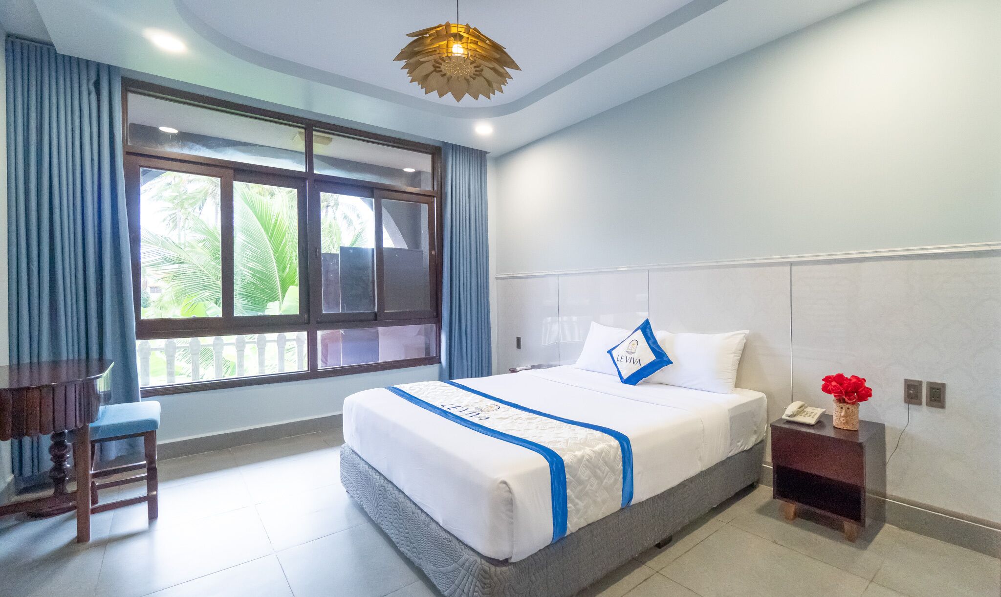 A hotel room with a bed, a desk, and a chair.