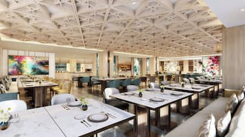 A spacious hotel dining area with multiple tables set for dining, a high ceiling with a geometric pattern, and modern decor.