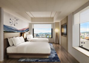 A modern hotel room with a large bed, a flat-screen TV, a city view, and a painting on the wall.