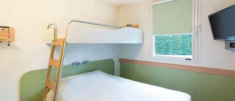 A bunk bed room with a window, a television on the wall, and a small shelf.