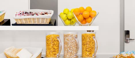 A buffet setup with various food items and containers.