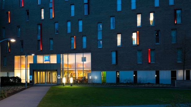 Un bâtiment moderne à la façade plate, doté de nombreuses fenêtres et d’une entrée bien éclairée.