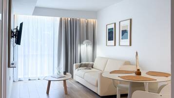 Una sala de estar moderna con un sofá, una mesa de centro y un comedor con sillas.