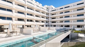 A modern hotel with a rooftop pool, outdoor seating, and a multi-story building. - Aparthotel Playa del Sol - Adults Only (San Bartolomé de Tirajana)