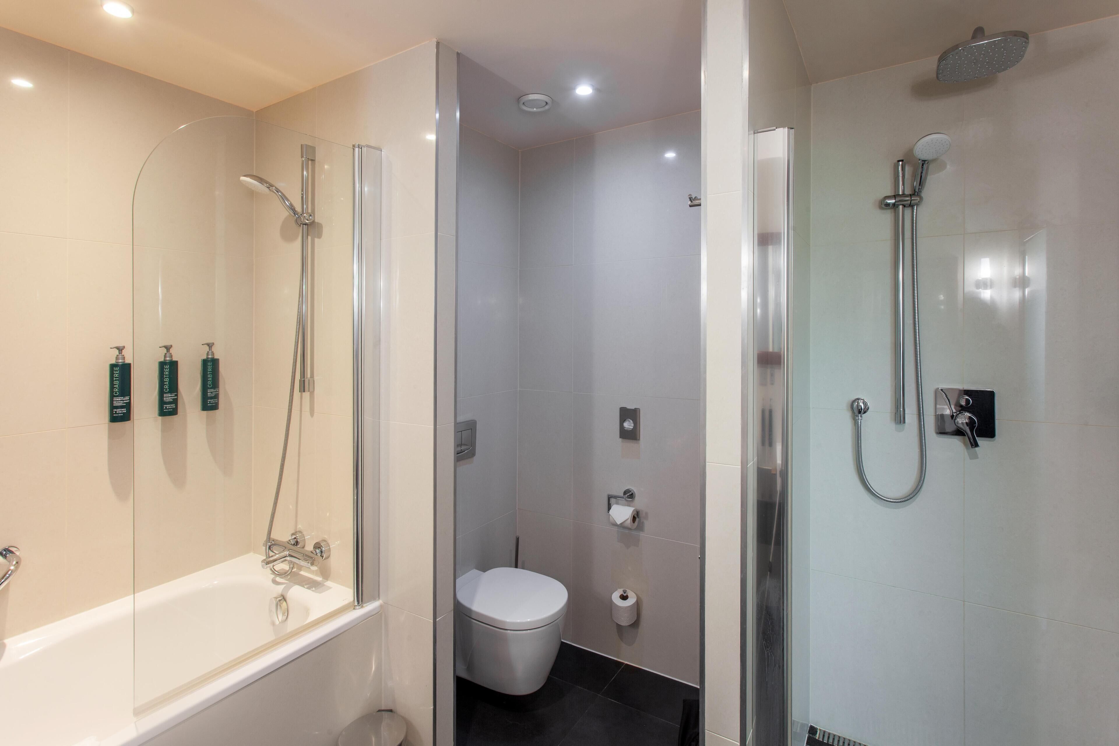 Un baño moderno con bañera, ducha e inodoro.
