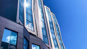 Un edificio moderno con ventanas de vidrio reflectante y un cielo azul despejado.