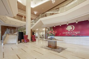 A spacious lobby with a grand staircase, a reception desk, and a decorative centerpiece. - DoubleTree by Hilton Bratislava (Bratislava)