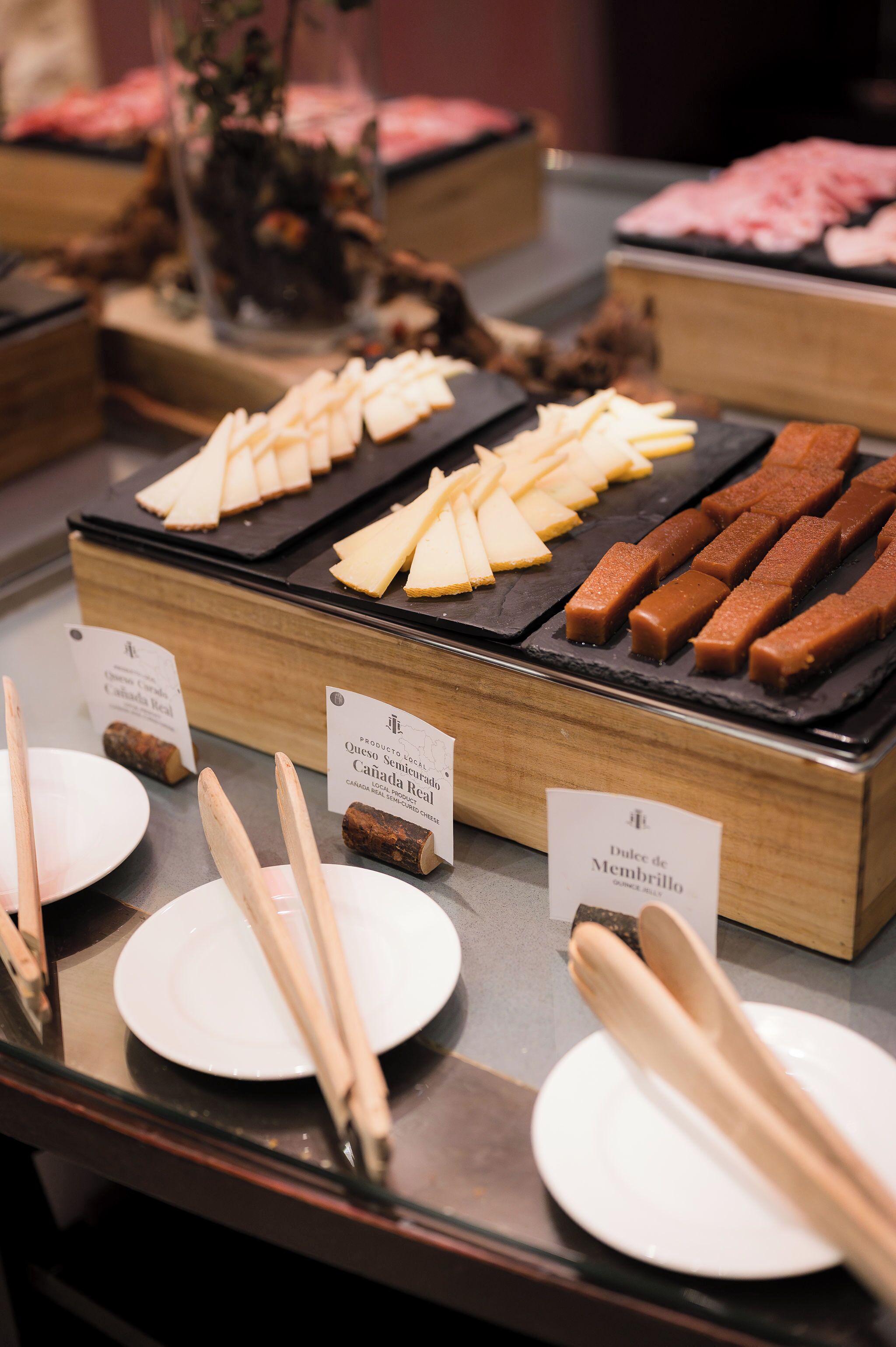 Un bufé con diferentes opciones de comida, incluyendo queso y pan.