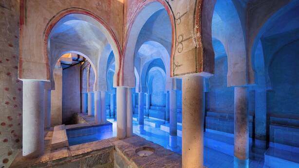 Une série d’arches aboutissant à une piscine au bout du couloir.