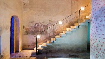 A staircase with stone steps and a metal railing, leading to an upper level.