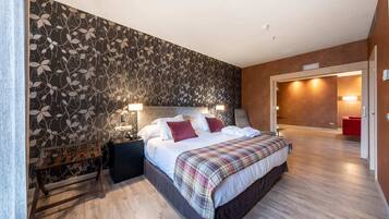 A bedroom with a bed, bedside tables, a bench, and a patterned wall.