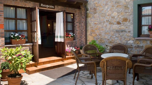 Un área de recepción con muebles de mimbre y plantas en macetas.