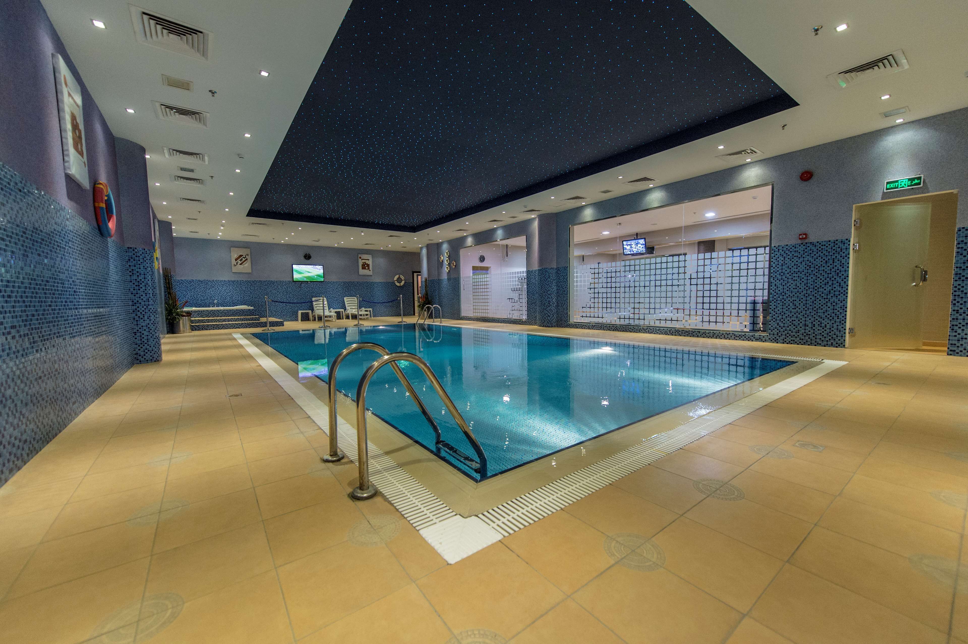 Une piscine dotée d’un plafond étoilé, de murs carrelés et d’un plancher en bois.