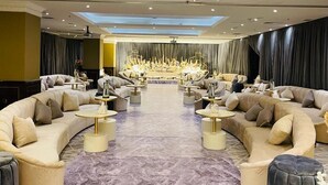 Un vaste salon doté de plusieurs espaces de détente, d’une scène centrale et d’une verrière.