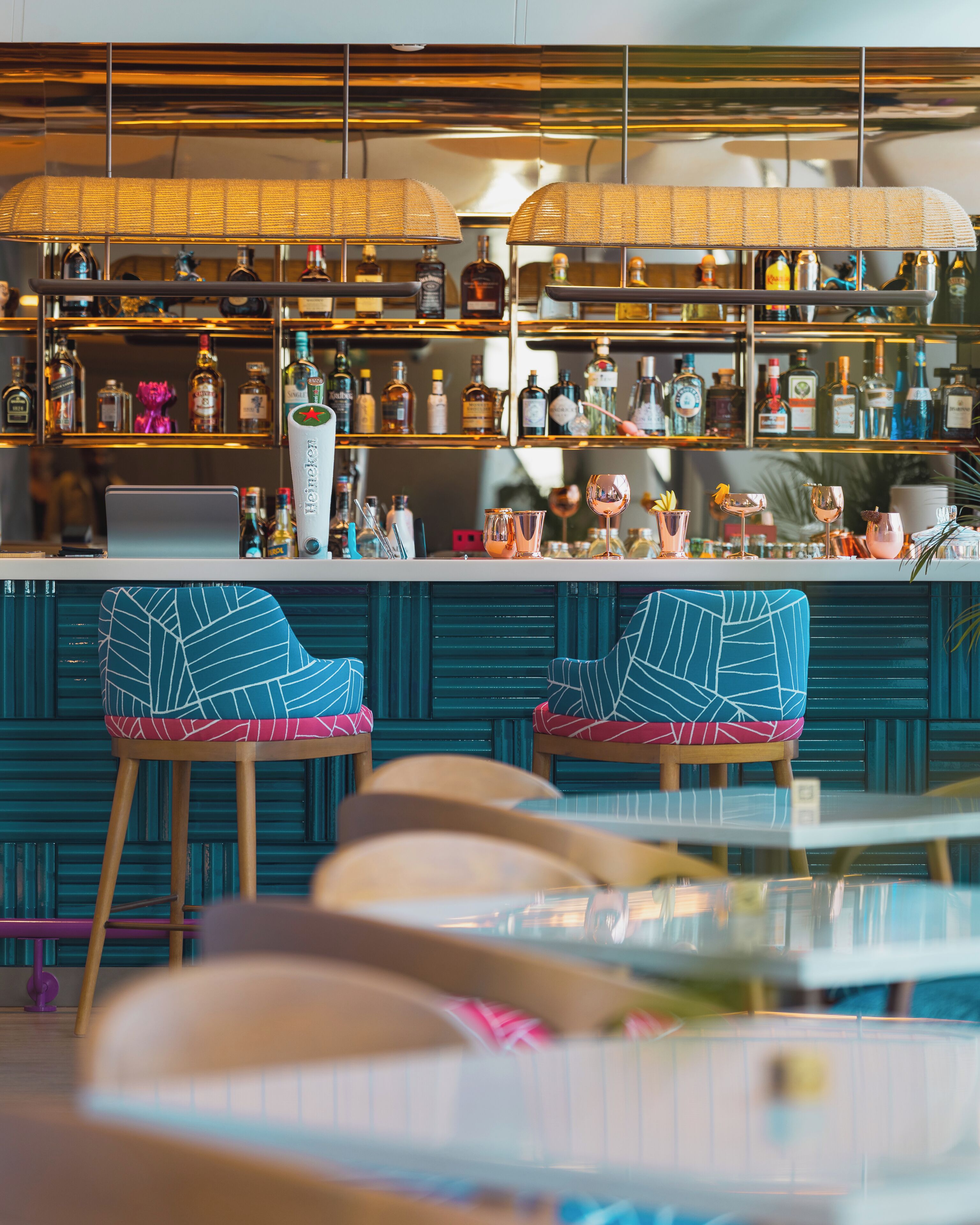 A bar area with stools, a counter, and shelves stocked with bottles.