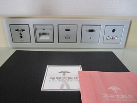 Un cuadro eléctrico de hotel con múltiples enchufes y una regleta.