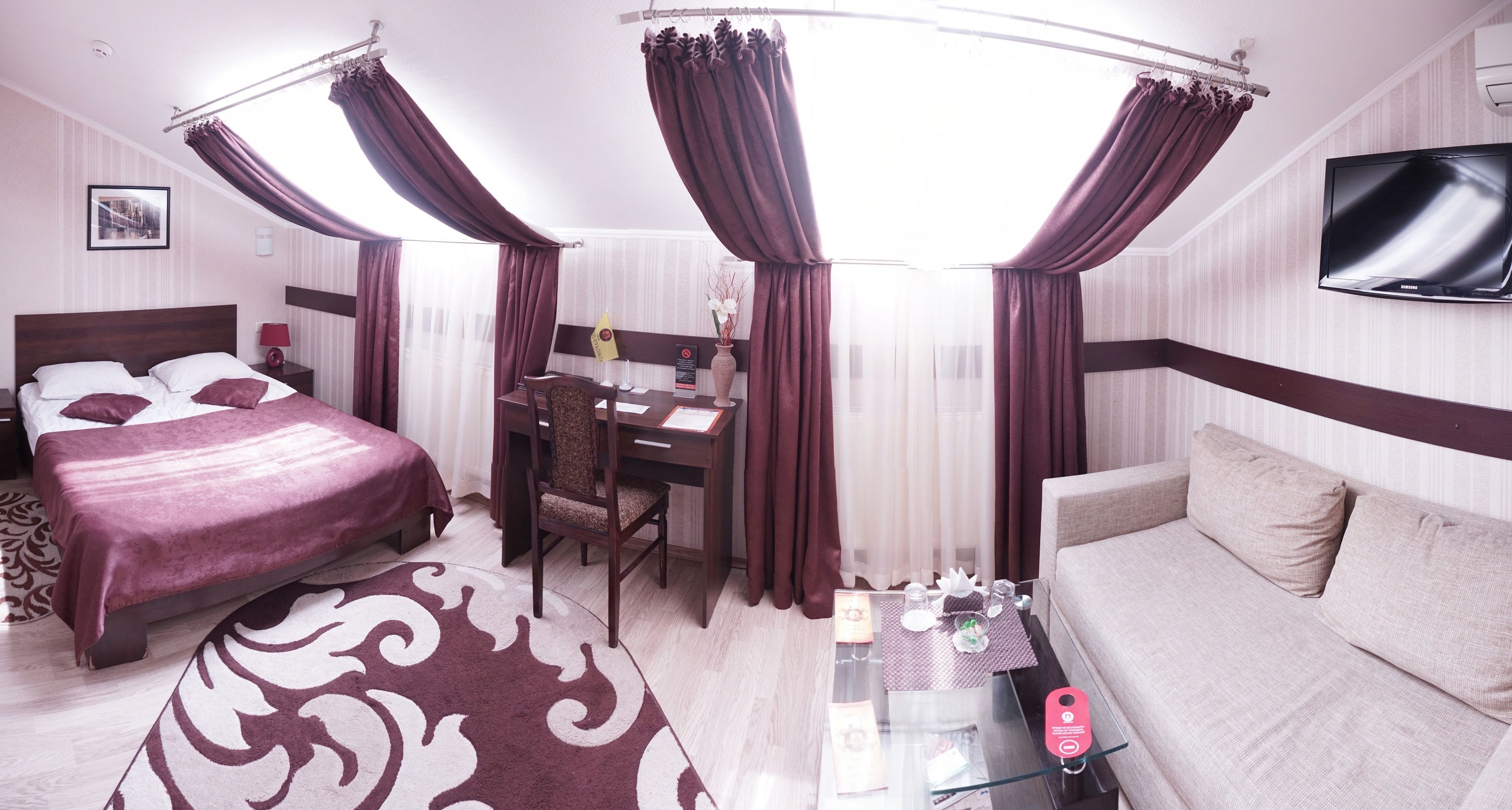 Una habitación de hotel con cama, escritorio y sofá.