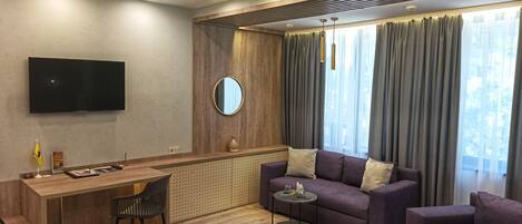 Una sala de estar moderna con un sofá, una mesa de centro, un televisor y un escritorio.
