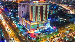 Ein mehrstöckiges Hotel mit auffälliger Beschilderung, mehreren Etagen und einer belebten Straße im Vordergrund.
