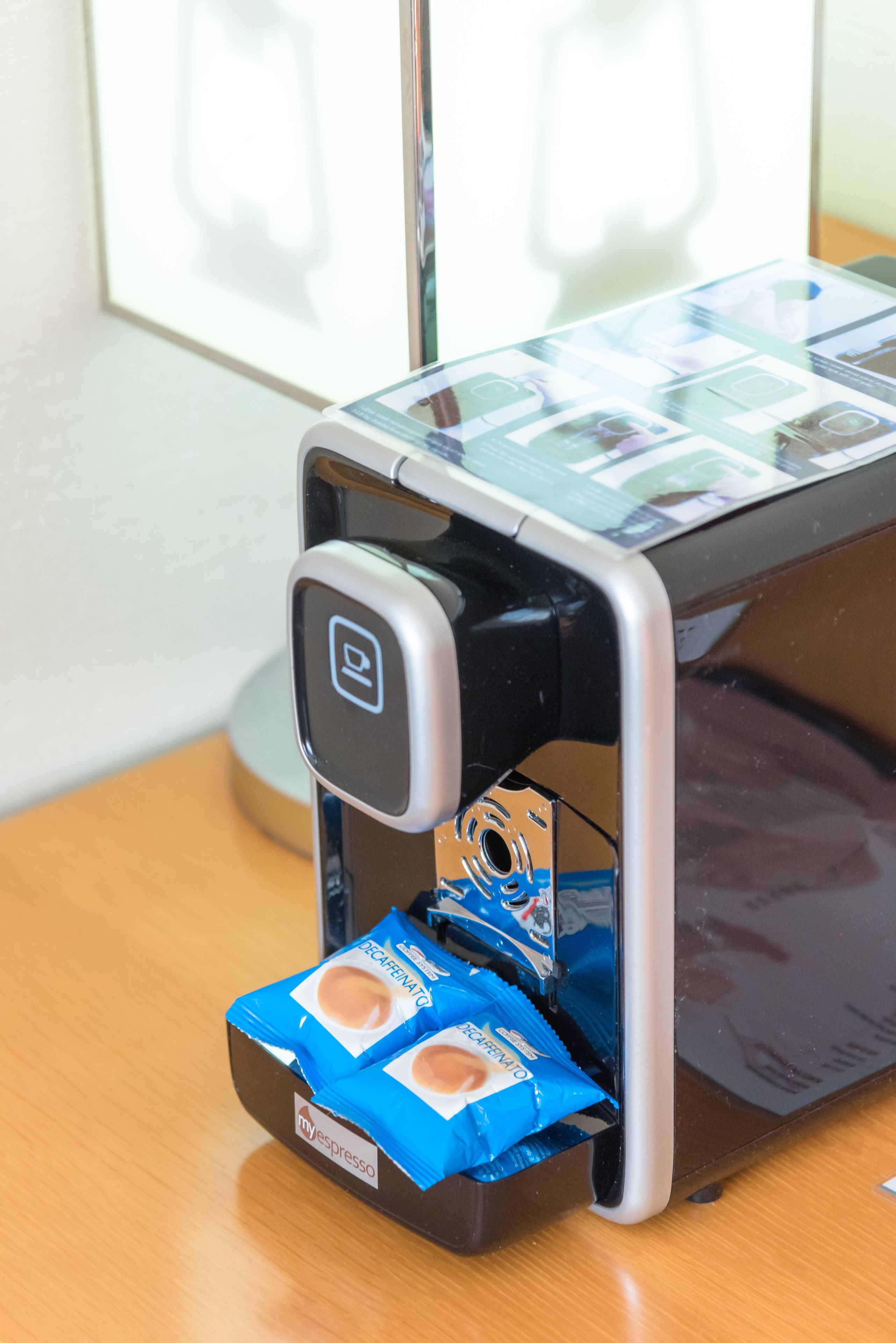 A coffee machine with a digital display and a coffee pod dispenser.