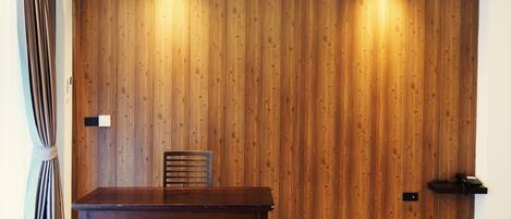 Un comedor con pared de paneles de madera, una mesa y una silla.