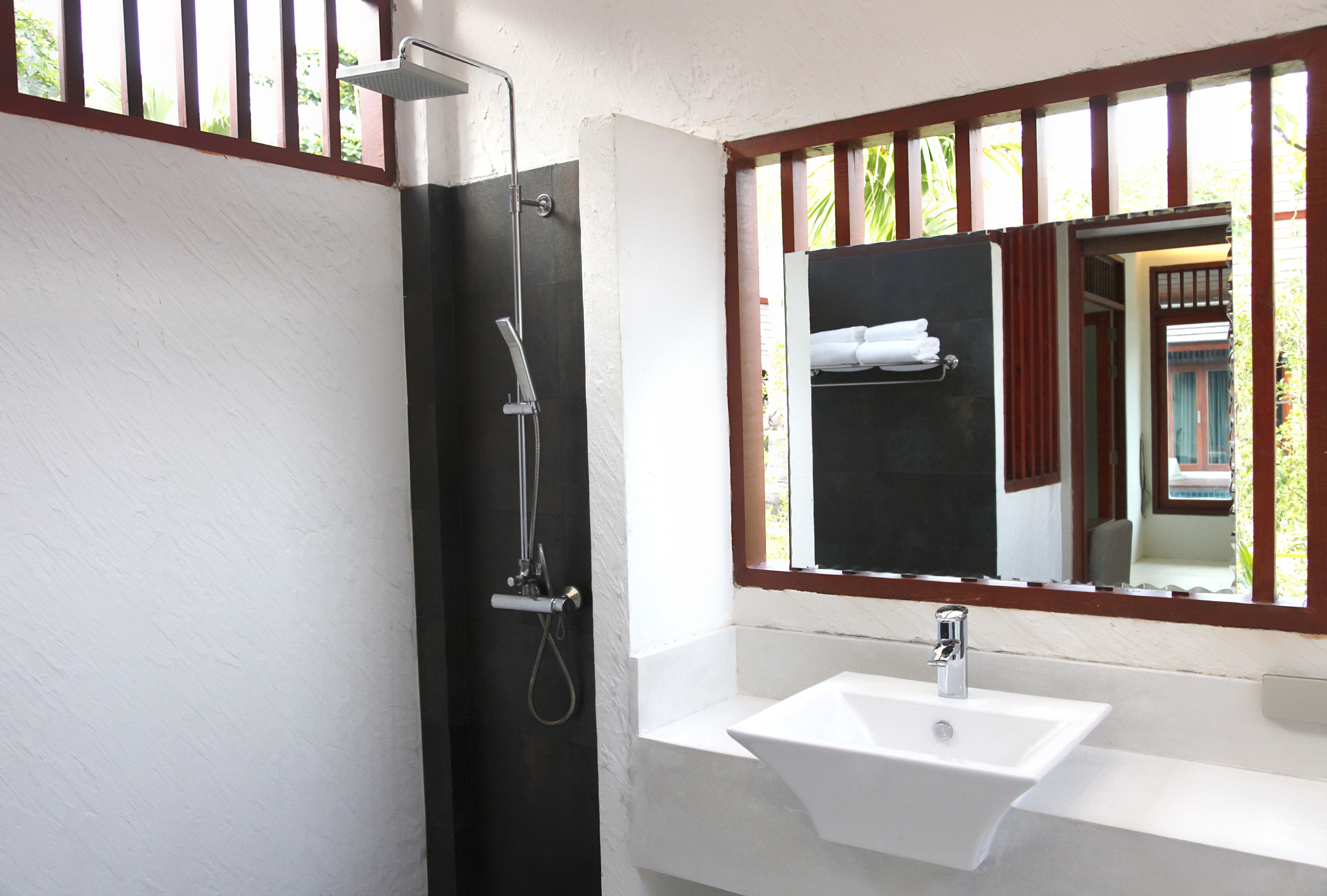 Ein Badezimmer mit Waschbecken, Spiegel und Dusche.