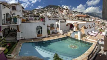 Una piscina al aire libre, sillones reclinables de piscina