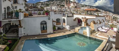 Una piscina al aire libre, sillones reclinables de piscina