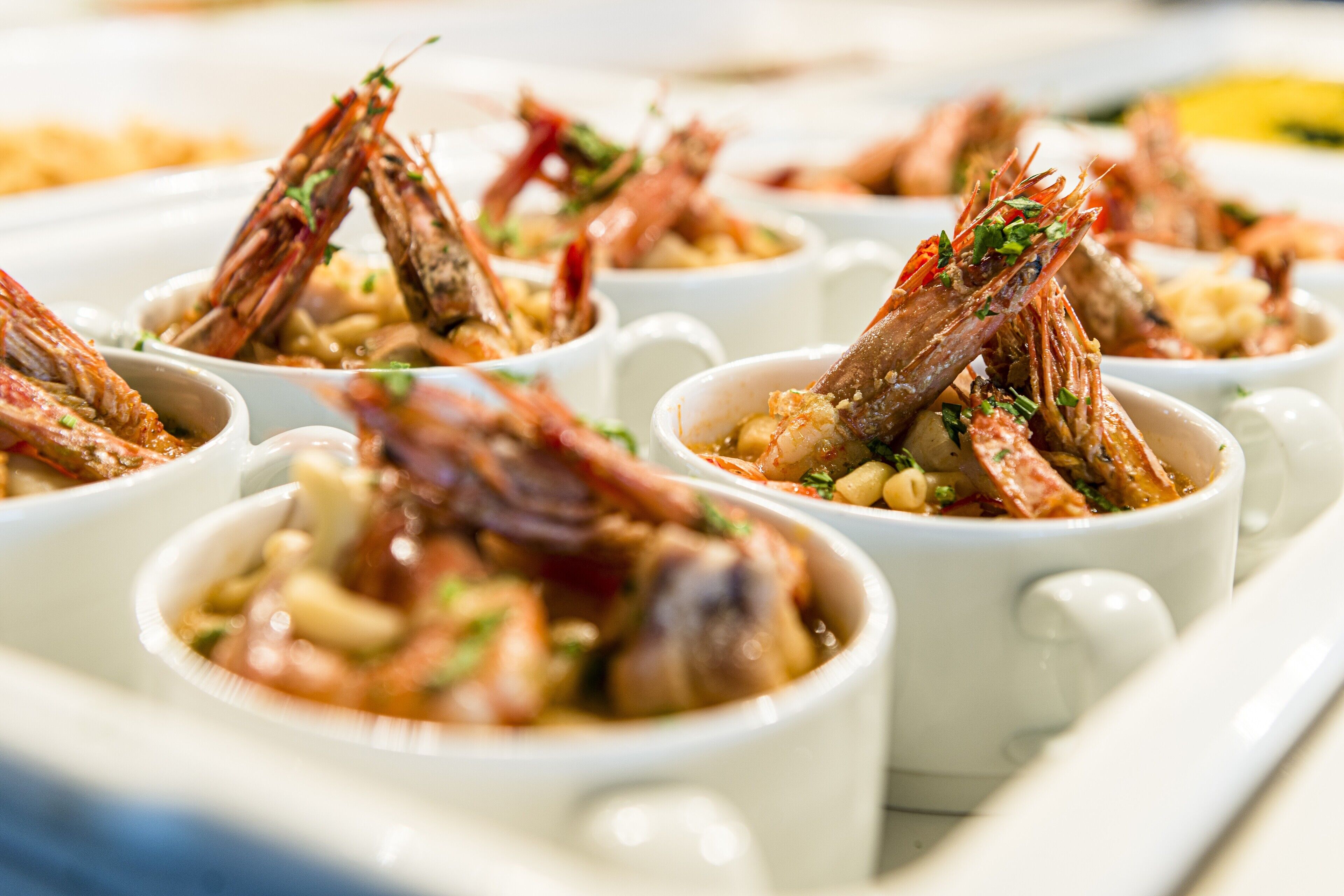 Un plato de camarones cocidos servido en recipientes individuales.