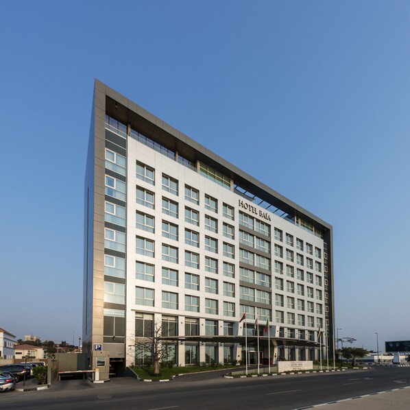 A modern hotel building with a flat facade, multiple windows, and a prominent entrance with a canopy. - Hotel Baía (Luanda)