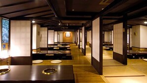 A traditional Japanese-style room with tatami flooring, low tables, and sliding doors.