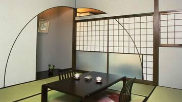 Una habitación tradicional japonesa con suelo de tatami, una mesa baja y paneles shoji.